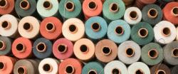 Textiles stacked on spools, multicolored