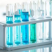 blue chemicals in beaker vials in lab setting