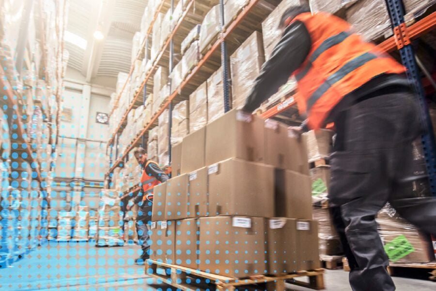 Worker pushing boxes through a warehouse