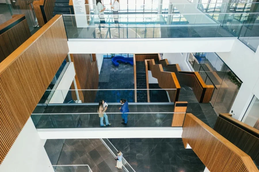 Confident and happy business people are walking and talking in office building hall corridor.