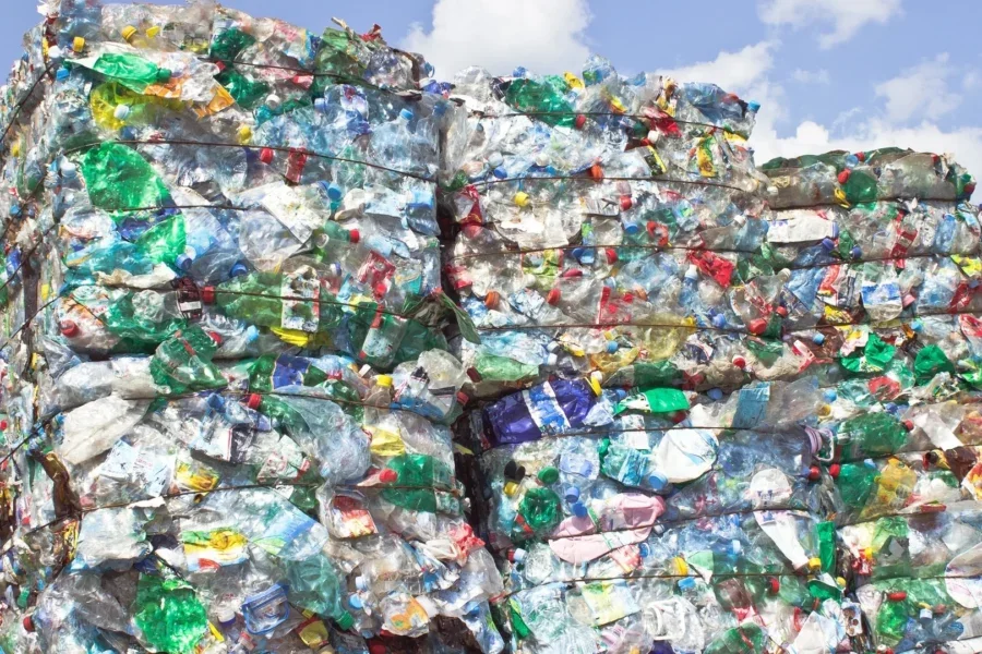 Stack of plastic bottles for recycling against blue sky