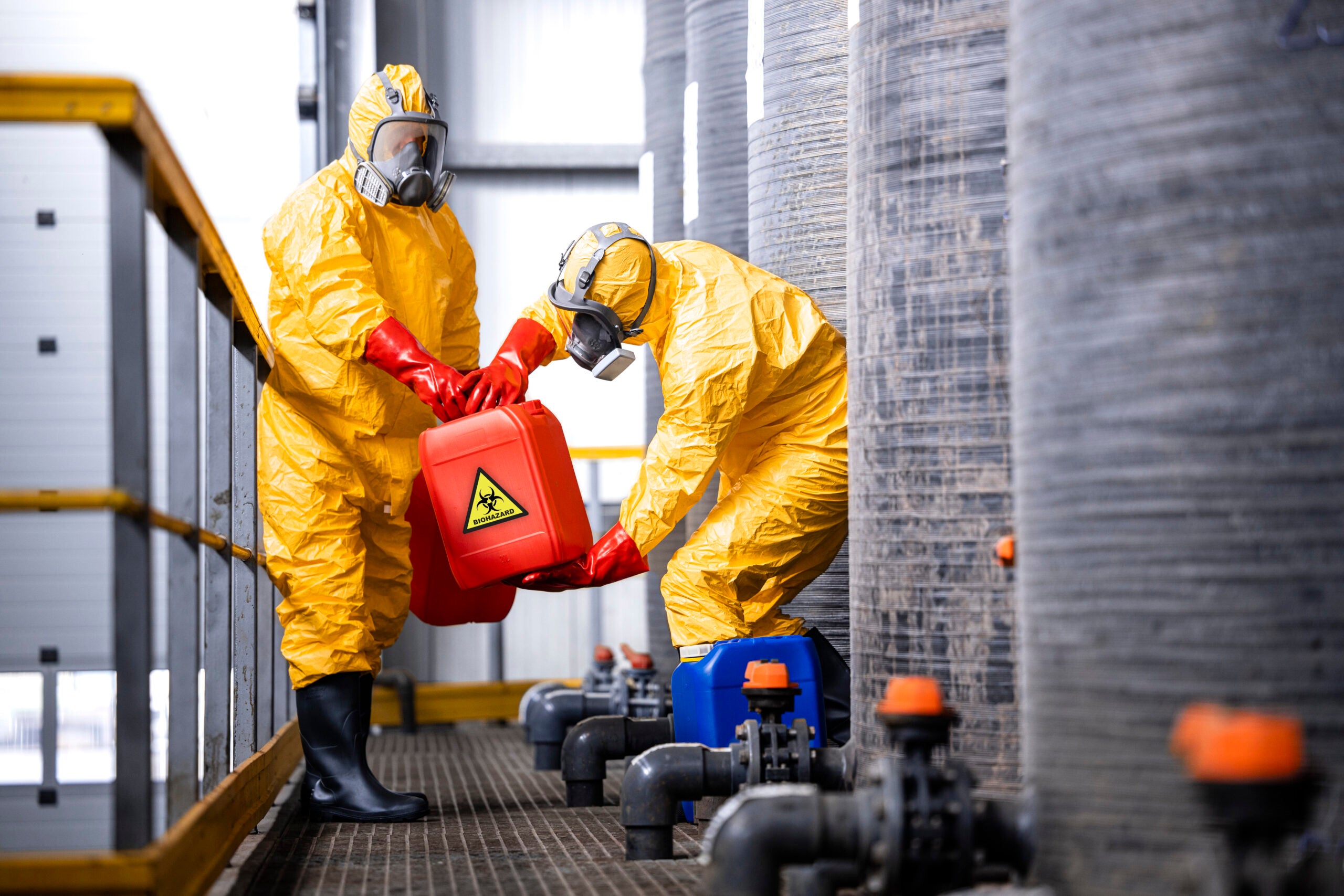 carefully handling toxic and dangerous biohazardous waste in chemicals factory.