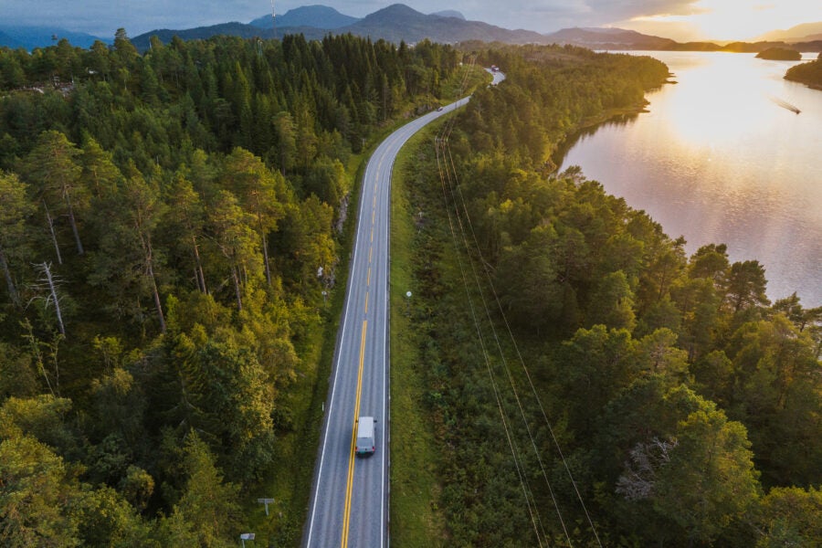Scenic aerial view of delivery truck on the road near the lake in Norway